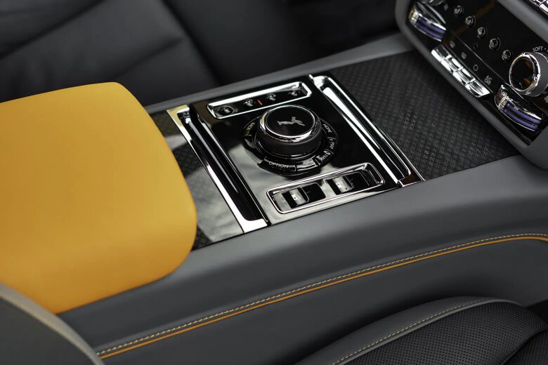 Detail van de middenconsole met draaiknop en bedieningselementen.