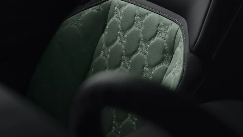 Close-up detail van de groen gequilte lederen stoelbekleding.
