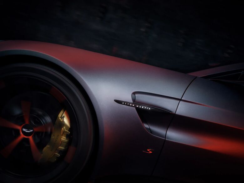Detail van het voorwiel en de flank van de Aston Martin Vantage S met gouden remklauw en Aston Martin badge