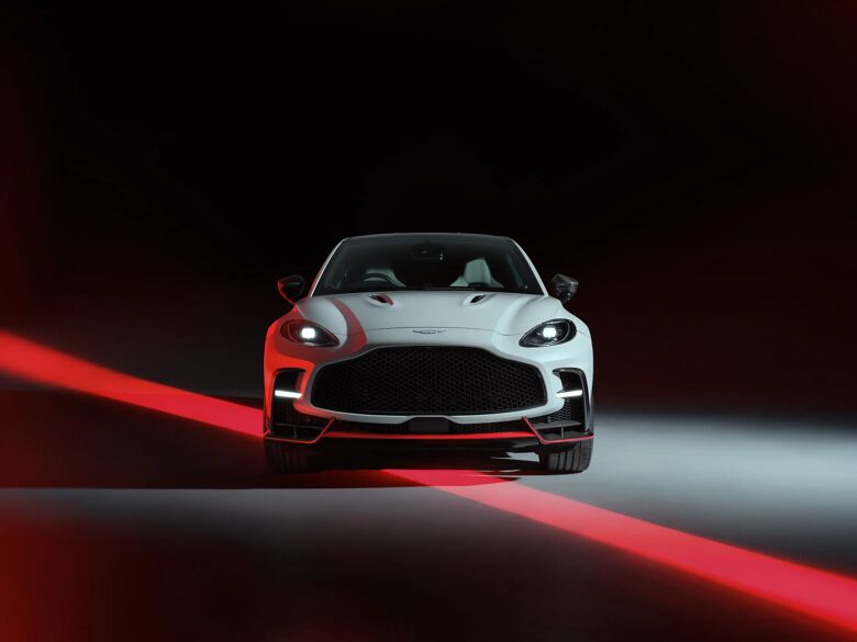 Witte Aston Martin DBX S recht van voren in een studio met rode belichting