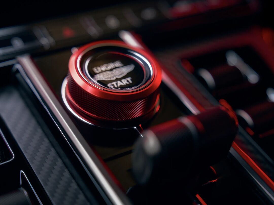 Close-up van de rode Engine Start-knop met Aston Martin-vleugels in de Vantage S