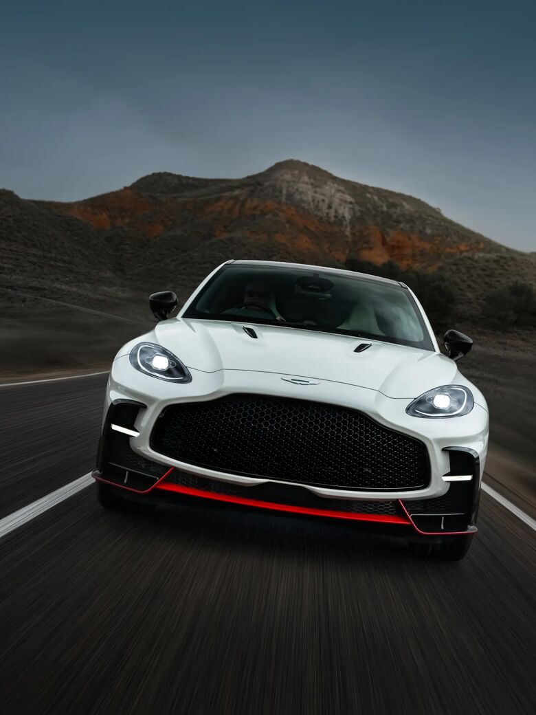 Witte Aston Martin DBX S recht van voren rijdend, met rode frontsplitter