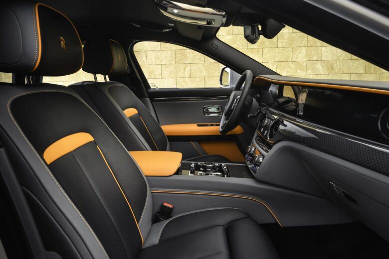 Interieur met zwart-oranje voorstoelen en dashboard van de Ghost Black Badge.