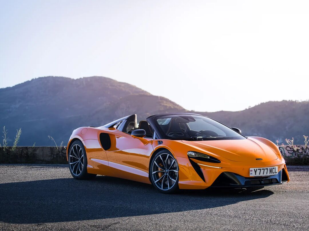 Oranje McLaren Artura Spider stilstaand op een bergweg