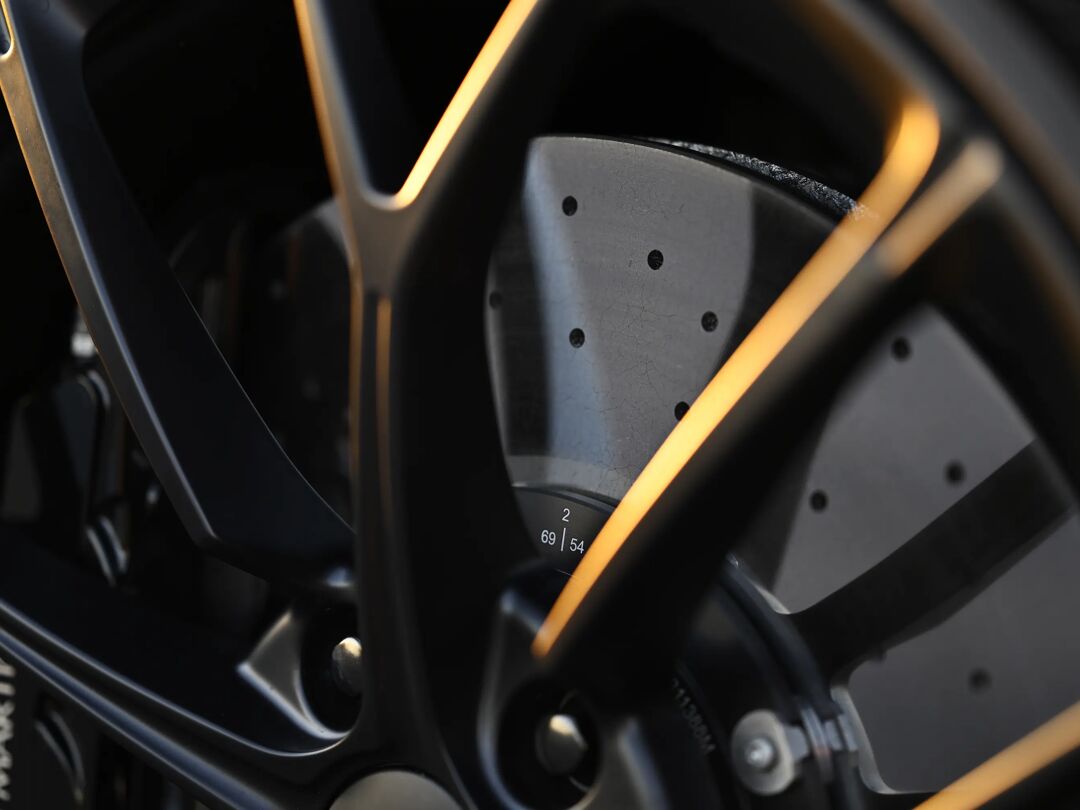 Close-up van de velg en geperforeerde remschijf van de Aston Martin Vantage