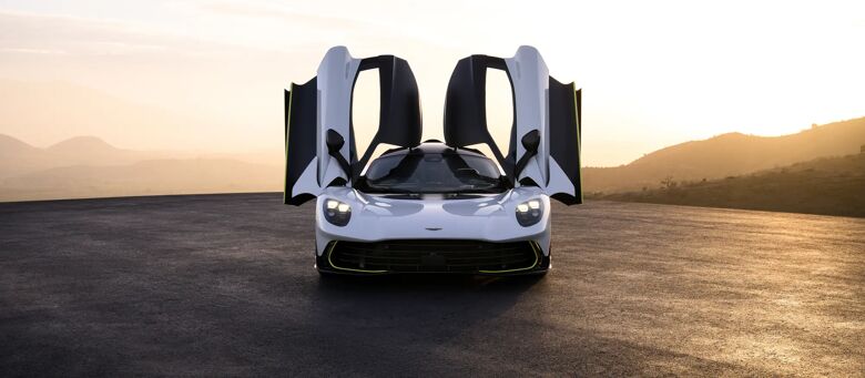 Aston Martin Valhalla met geopende vleugeldeuren bij zonsondergang