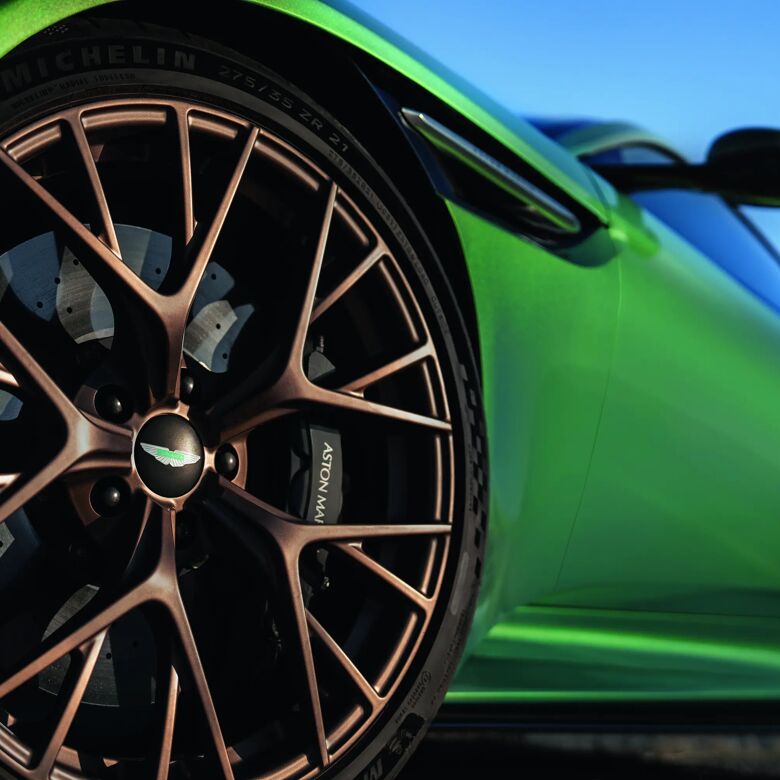 Close-up van de bronskleurige velg van de groene Aston Martin DB12
