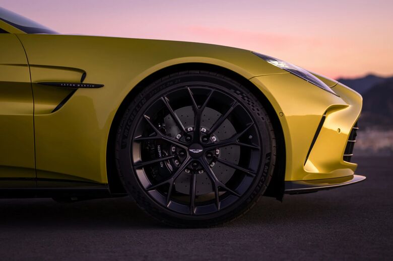 Detail van voorwiel en flank van de gele Aston Martin Vantage in de schemering