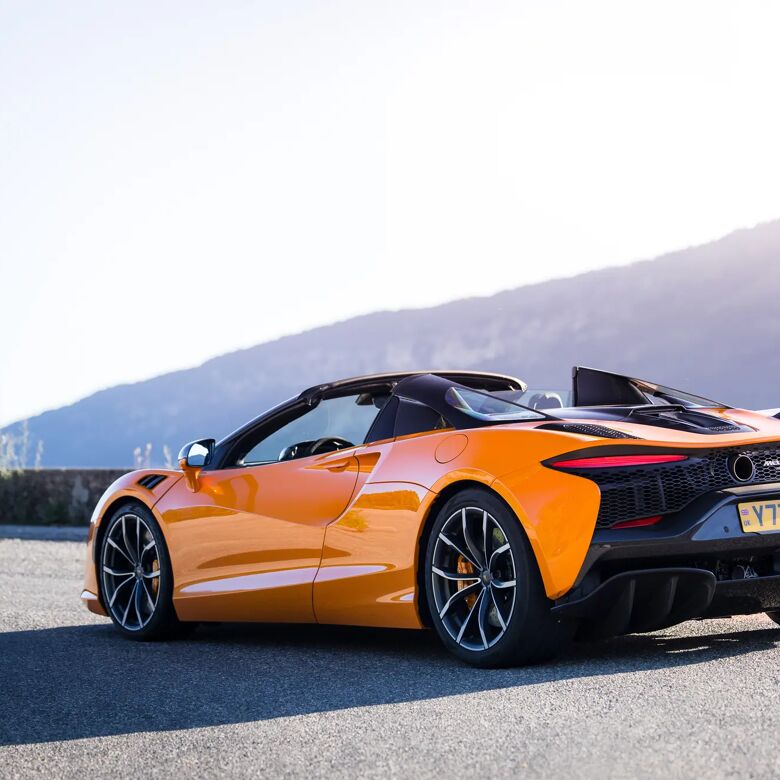 Oranje McLaren Artura Spider stilstaand op een bergweg