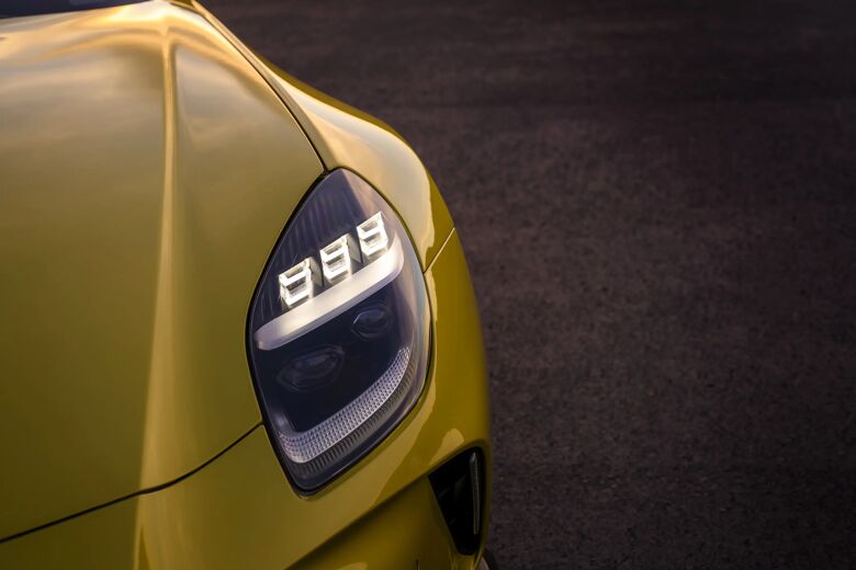 Detail van de koplamp op de gele carrosserie van de Aston Martin Vantage