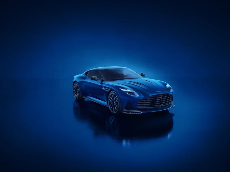 Blauwe Aston Martin DB12 S in vooraanzicht in een studio met blauwe belichting en spiegeling
