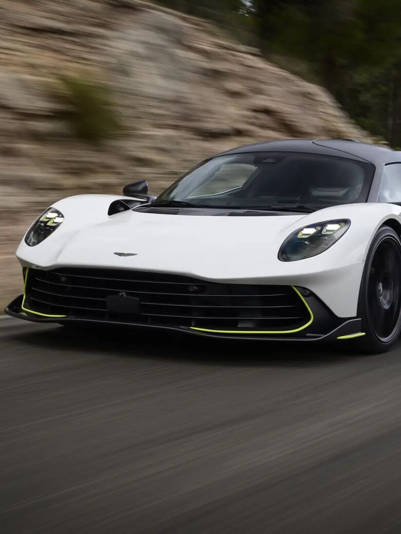 Aston Martin Valhalla rijdend op bewolkte bergweg, driekwart vooraanzicht
