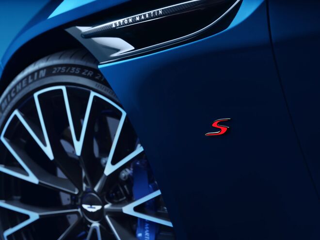 Detail van het achterwiel van de blauwe Aston Martin DB12 S met rood S-logo en Aston Martin-belettering